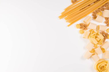 Yiyecek ve içecek konsepti - beyaz arka planda çeşitli pişmemiş makarna. Üst görünüm