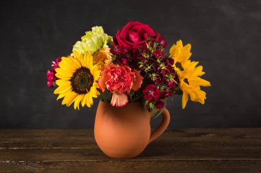 Toprak kap karanlık bir arka plan üzerinde beyaz sarı ve kırmızı çiçekler Buket. İçin 8 Mart Dünya Kadınlar günü vintage ahşap sonsuz takvim