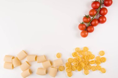 Beyaz arka plan üzerinde üstten görünüm izole yemek pişirmek için malzemelerle çiğ makarna. Metin, düz için kopya yer yatıyordu