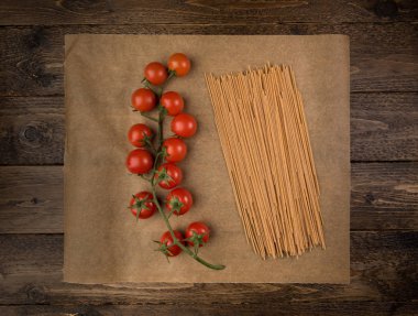Makarna ve koyu ahşap arka plan kopya alanı ile domates. Üstten Görünüm. Vejetaryen yiyecekler, sağlık veya pişirme kavramı