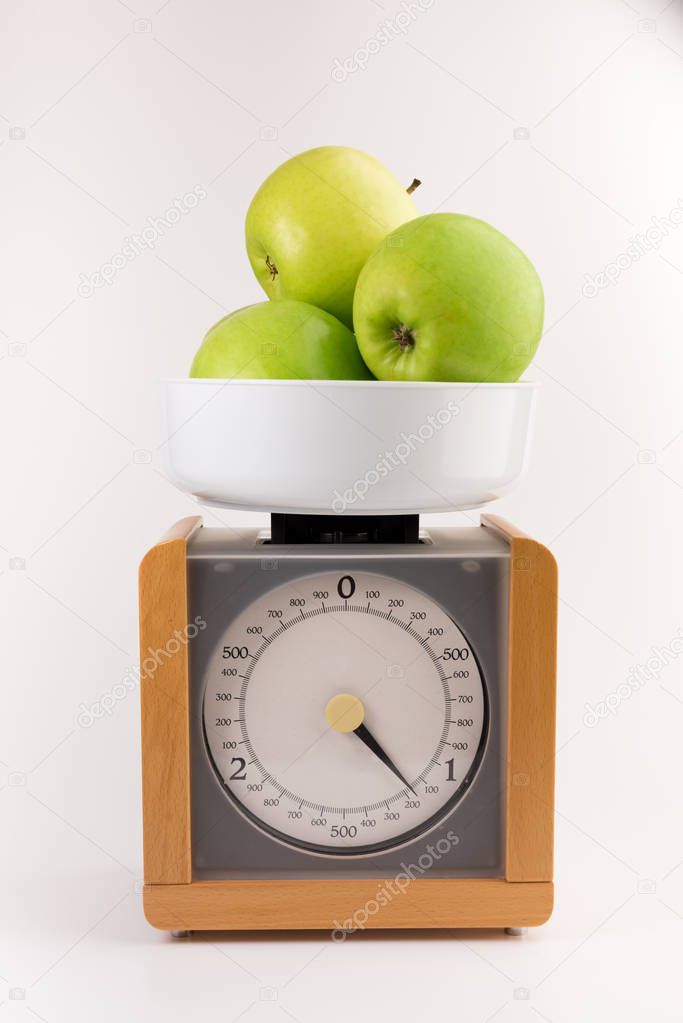vintage wooden kitchen scales isolated on white background  with green apples
