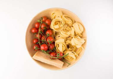 Pişmemiş makarna, domates ve parmesan peyniri beyaz arka plan üzerinde üstten görünüm izole kase. Düz yatıyordu