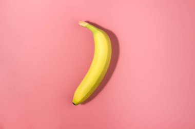 Güçlü gölge ile pembe bir arka plan üzerinde tek muz