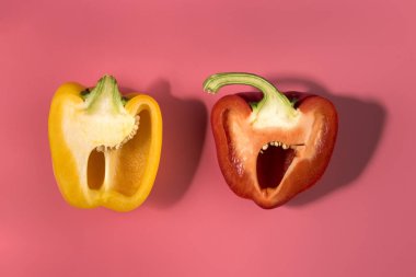 Doğal organik kırmızı ve sarı Bulgar dolmalık biber trendi pembe arka plan üzerine dilimlenmiş. Üstten Görünüm. Sağlıklı gıda kavramı. Düz yatıyordu. Uzay kopyalayın. Minimalizm tarzı. Sebze vitaminler rustik tarzı. Ülke Köyü tarım