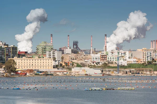Beyaz kadar devam çelik fabrikası Taranto, Puglia, bacasından duman. İtalya