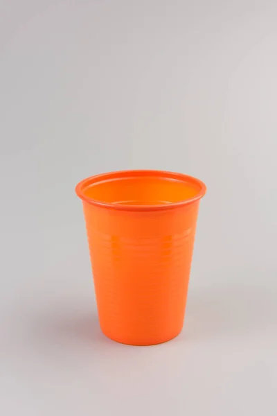 Okrągły Pomarańczowy Plastikowy Kubek Białym Tle Szarym Tle — Zdjęcie stockowe