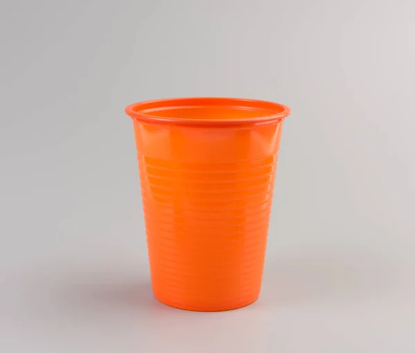 Okrągły Pomarańczowy Plastikowy Kubek Białym Tle Szarym Tle — Zdjęcie stockowe