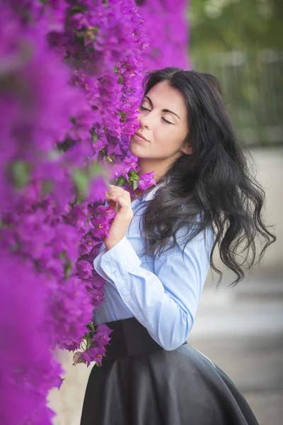 花に囲まれた美しい若い女性の屋外ファッション写真 春の花 — ストック写真