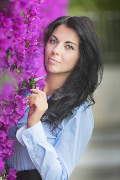 Schöne Junge Frau Auf Einem Hintergrund Aus Rosa Blumen Das — Stockfoto