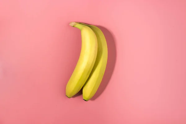 コントラスト シャドウとピンクの背景の つのバナナ — ストック写真