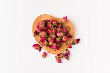 Tea gül tomurcukları beyaz arka plan üzerinde üstten görünüm izole bir ahşap daire üzerinde