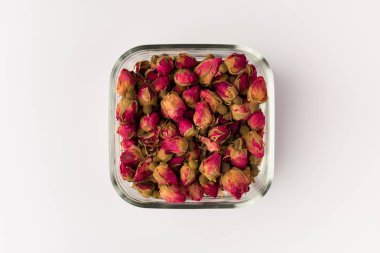 bir cam kase beyaz arka plan üzerinde üstten görünüm izole içme Tea gül tomurcukları