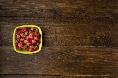 ahşap arka plan üzerinde üstten görünüm izole kase içme bir kil Tea gül tomurcukları