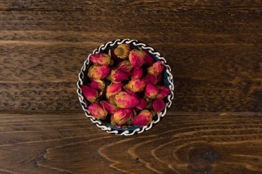 ahşap arka plan üzerinde üstten görünüm izole kase içme bir kil Tea gül tomurcukları