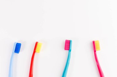 Kırmızı, pembe, mavi ve açık mavi diş fırçaları. Dişler, diş kavramı dikkat çekici. Düz yatıyordu fotoğraf, kopya alanı, üstten görünüm