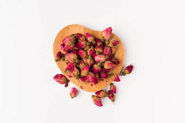 Tea gül tomurcukları beyaz arka plan üzerinde üstten görünüm izole bir ahşap daire üzerinde