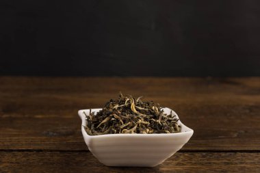 yeşil çay siyah arka plan üzerine ahşap masa üzerinde izole beyaz bir kase kuru