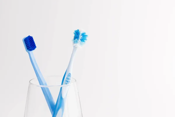 杯子与新的和使用的牙刷查出在白色背景 牙科保健 — 图库照片