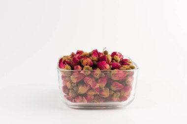 bir cam kase beyaz arka plan üzerinde izole içme Tea gül tomurcukları