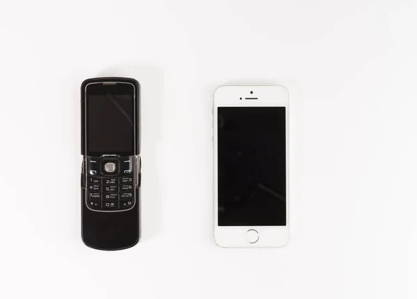 Smartphone ve beyaz arka plan üzerinde izole eski teknoloji telefon