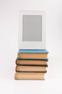 Beyaz arka plan üzerinde izole düzenli eski kitap yığını üst kısmında elektronik kitap