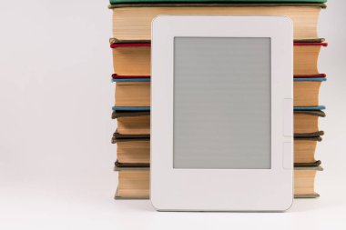 Beyaz arka plan üzerinde izole düzenli eski kitap yığını ile elektronik kitap