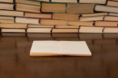 Kitapların arka plan ile masada boş not defteri