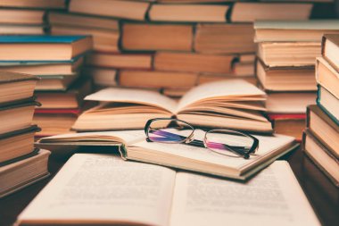 Açık kitap ve eğitim arka plan için daha sonra tekrar okul kavramı bulanık odak ile kütüphane odada ahşap masa üzerinde gözlük