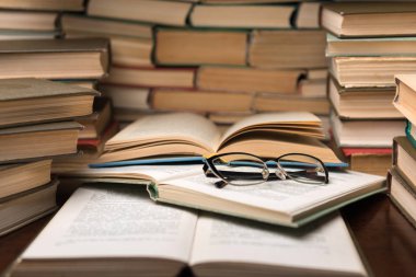 Açık kitap ve eğitim arka plan için daha sonra tekrar okul kavramı bulanık odak ile kütüphane odada ahşap masa üzerinde gözlük