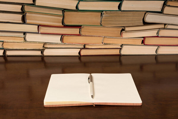 notebook and pen on the background of books