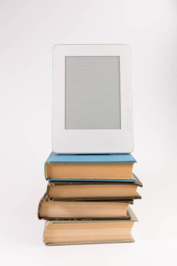 Beyaz arka plan üzerinde izole düzenli eski kitap yığını üst kısmında elektronik kitap
