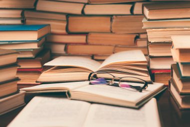 Açık kitap ve eğitim arka plan için daha sonra tekrar okul kavramı bulanık odak ile kütüphane odada ahşap masa üzerinde gözlük