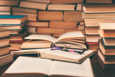 Açık kitap ve eğitim arka plan için daha sonra tekrar okul kavramı bulanık odak ile kütüphane odada ahşap masa üzerinde gözlük