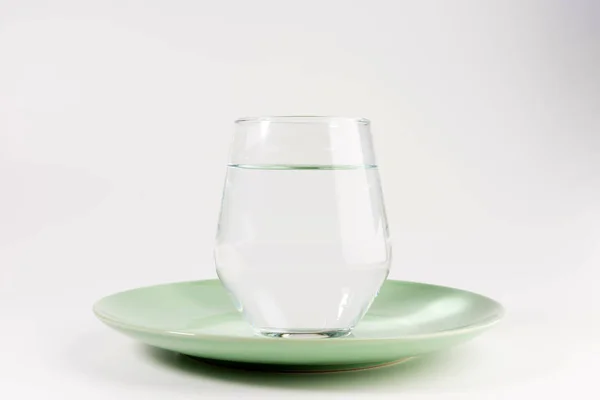 Glas Wasser Einem Teller Isoliert Auf Weißem Hintergrund — Stockfoto