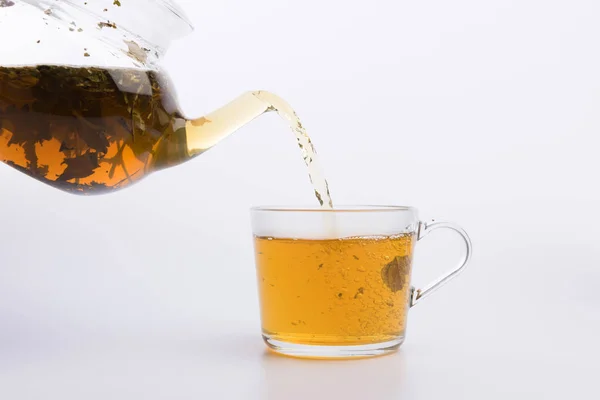 Стеклянный Чайник Наливая Зеленый Чай Чашку Изолированы Белом — стоковое фото
