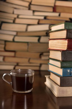  Kupası ve ahşap bir masa üzerine pek çok kitap