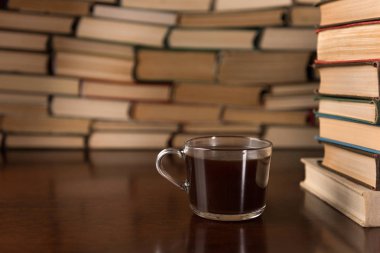 Kupası ve ahşap bir masa üzerine pek çok kitap