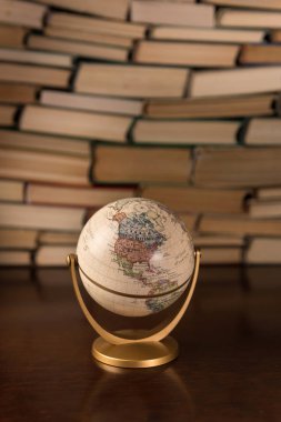  Küre ve ahşap bir masa üzerine pek çok kitap