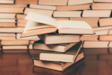Tahta masanın üzerinde bir yığın kitap var.