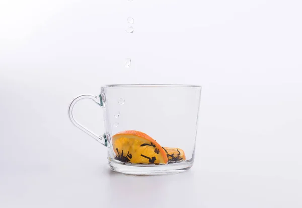 水倒进玻璃杯与红茶和柠檬隔离在白色背景 — 图库照片