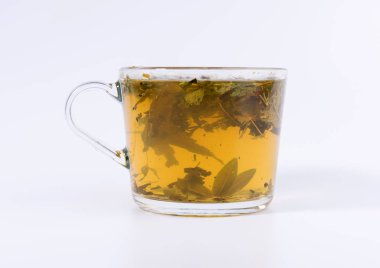 Beyaz arka planda izole şeffaf bir bardak yeşil bitkisel çay