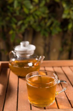 Ahşap masa açık havada yeşil çayı ile kompozisyon. Kilo kaybı kavramı, doğa arka plan