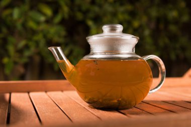 Ahşap tablo açık havada yeşil çay çaydanlık