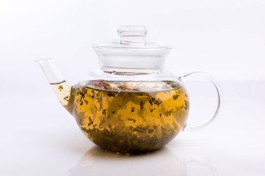 Bitki çayı ve beyaz arka plan üzerinde izole gül ile cam çaydanlık