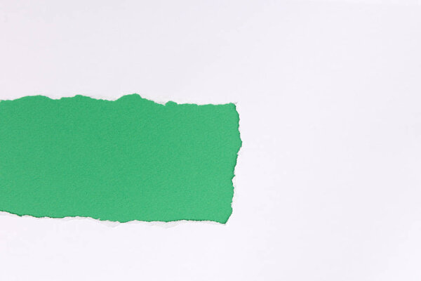 White torn paper over green background