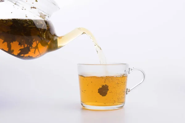 Стеклянный Чайник Наливая Зеленый Чай Чашку Изолированы Белом — стоковое фото