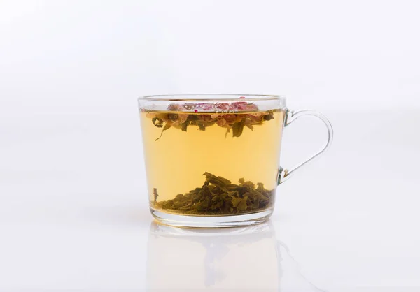 白い背景の上の熱い芳香のバラ茶のガラスのコップ — ストック写真