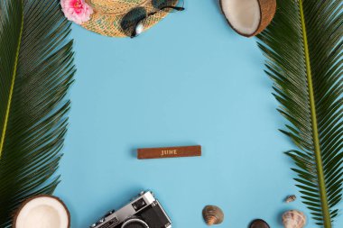 Mavi pastel renk arka plan üzerinde kamera, güneş gözlüğü ve panama şapka ile Yaratıcı Düz yatıyordu moda tarzı