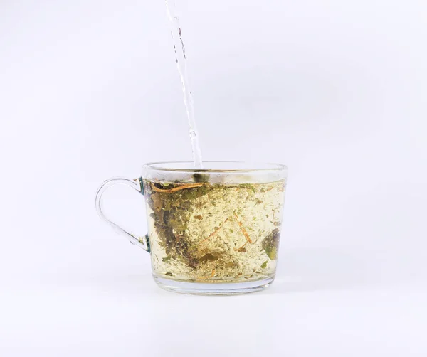 お茶は 白い背景で隔離のガラスのコップに熱湯を注ぐ — ストック写真