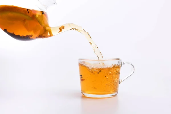 白い背景で隔離のカップにお茶を注ぐガラスのティーポット — ストック写真